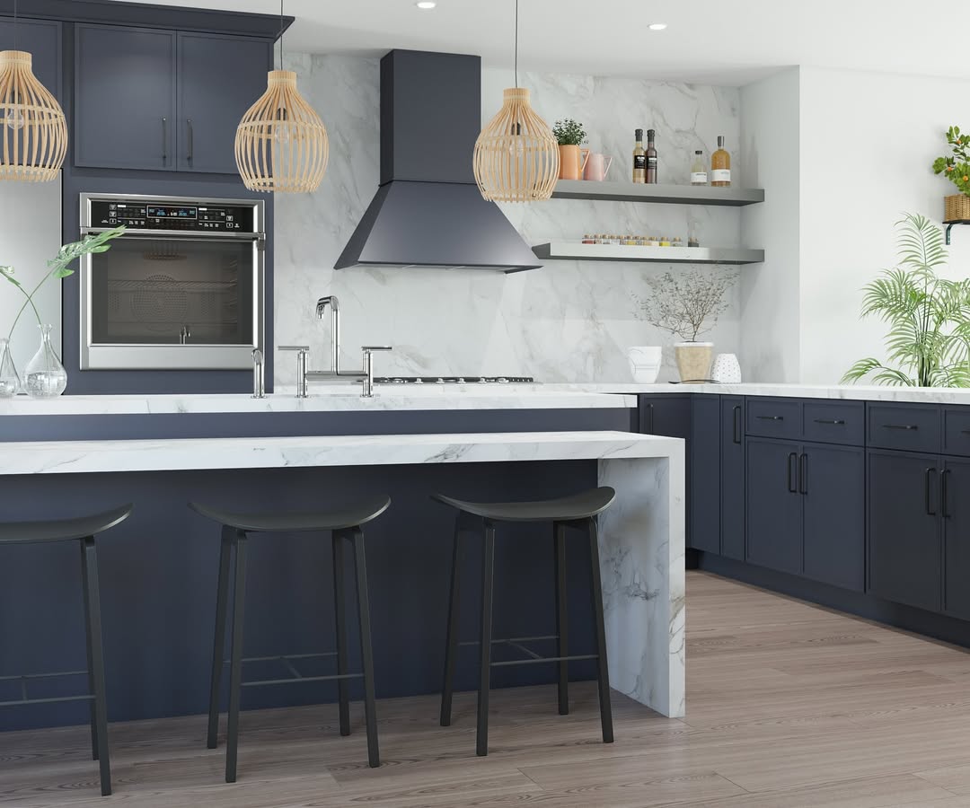 Modern kitchen with navy cabinets, marble countertops, open shelves, built-in oven, pendant lights, and decorative plants on light wood flooring—showcasing stunning kitchen colors and top kitchen trends 2025.