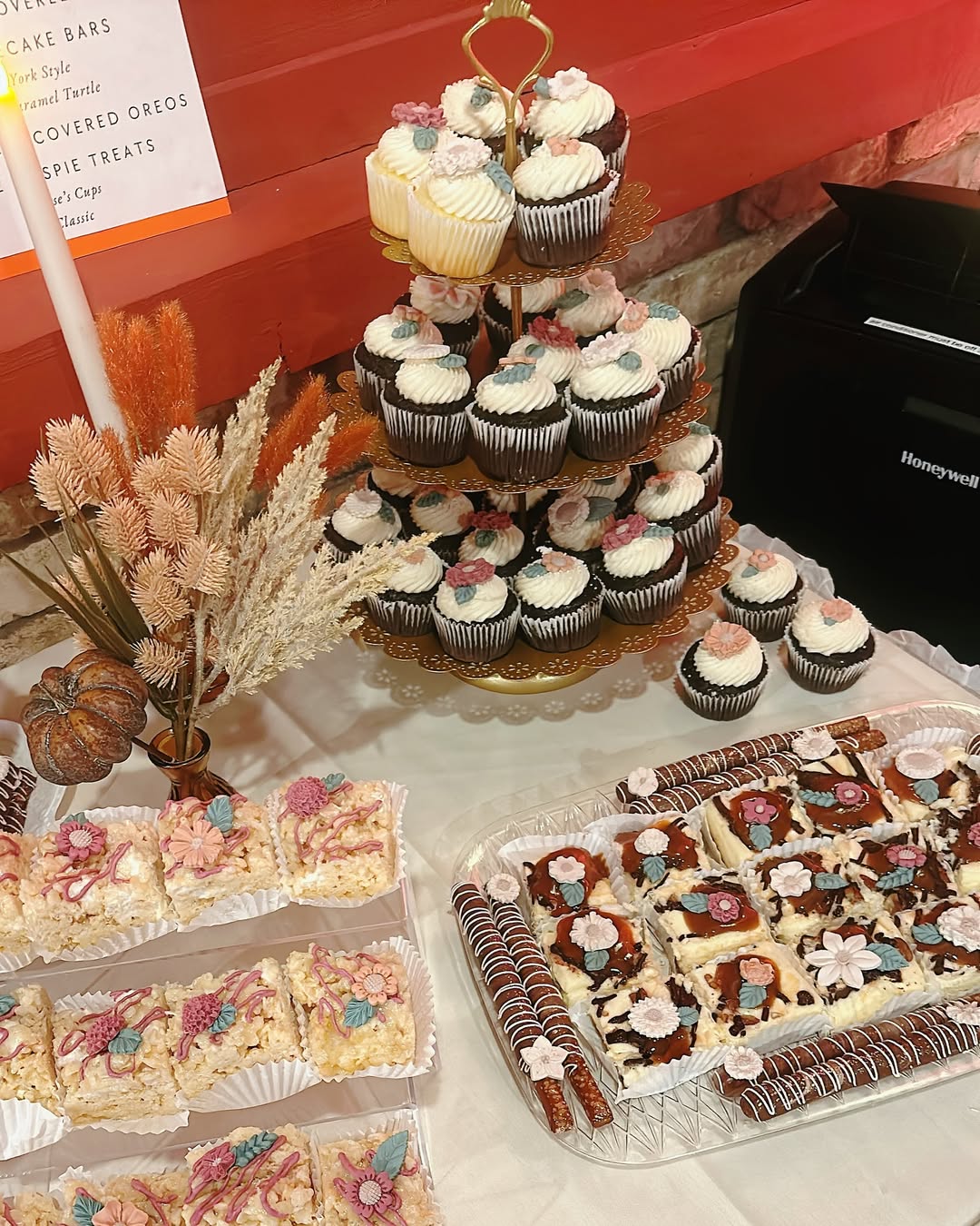 Discover stunning dessert table ideas featuring pretty desserts like cupcakes on a tiered stand, decorated rice crispy treats, chocolate-drizzled pretzel rods, and dessert bars—all adorned with floral decorations for any occasion.
