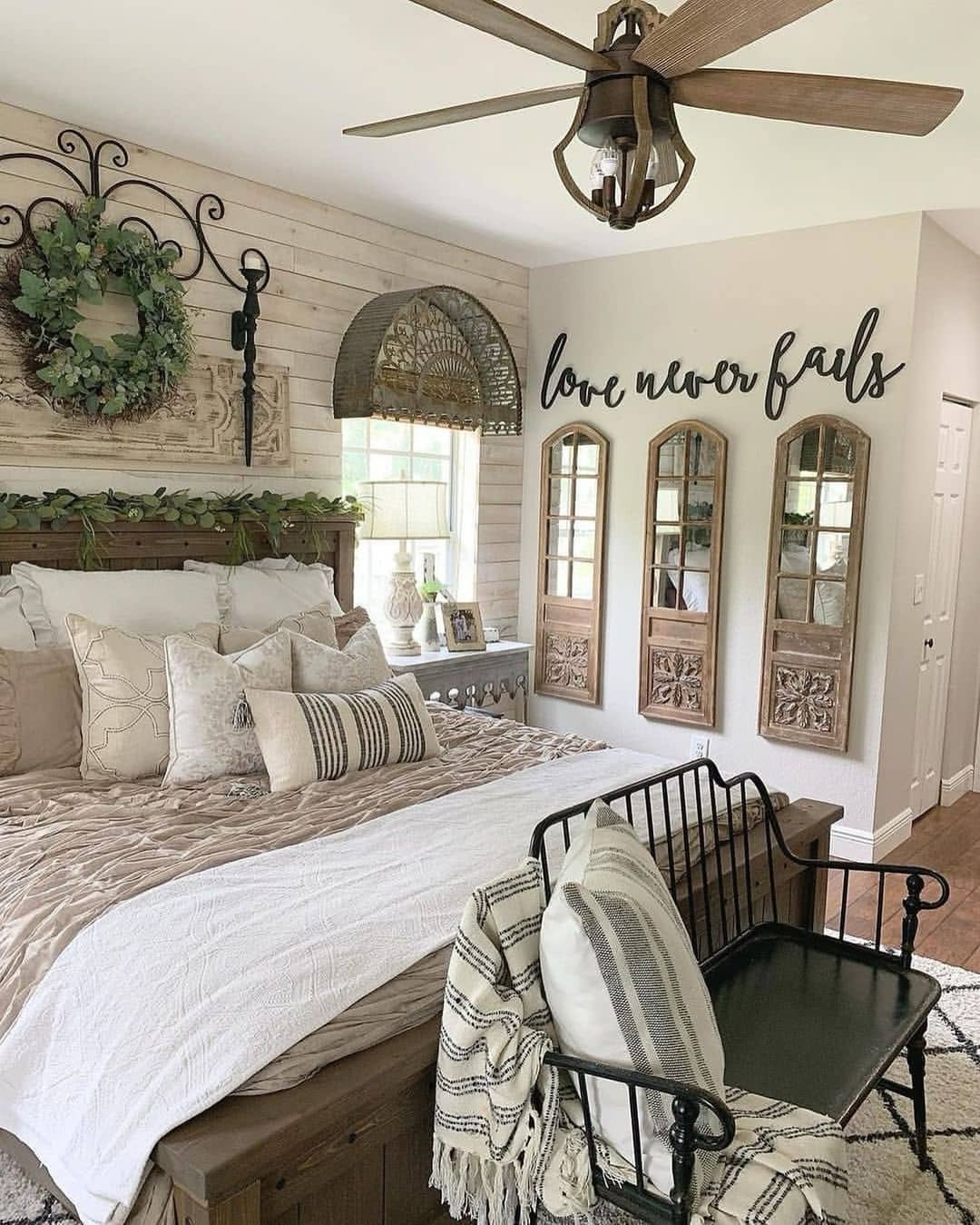 A cozy rustic bedroom with charming decor, featuring a neatly made bed, decorative pillows, wall art reading