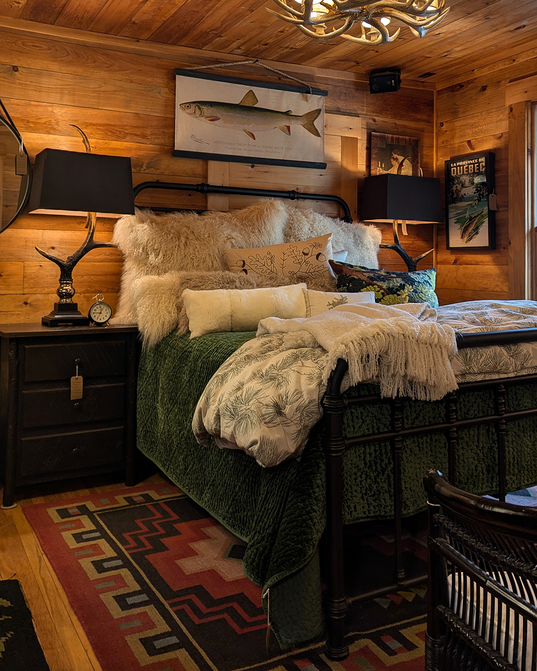 A cozy rustic bedroom featuring a bed with pillows and a lamp, set against charming wood walls—perfect for those seeking inspiring rustic bedroom ideas.