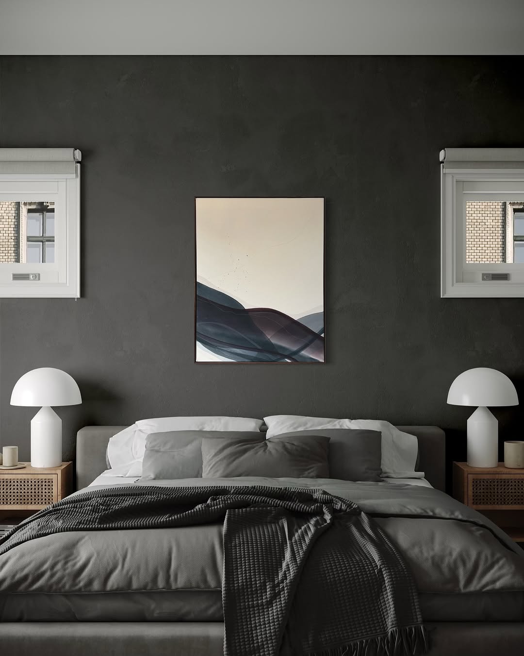 A modern dark feminine bedroom with a striking dark accent wall, centered bed, gray bedding, two nightstands with lamps, and abstract art between two small windows.