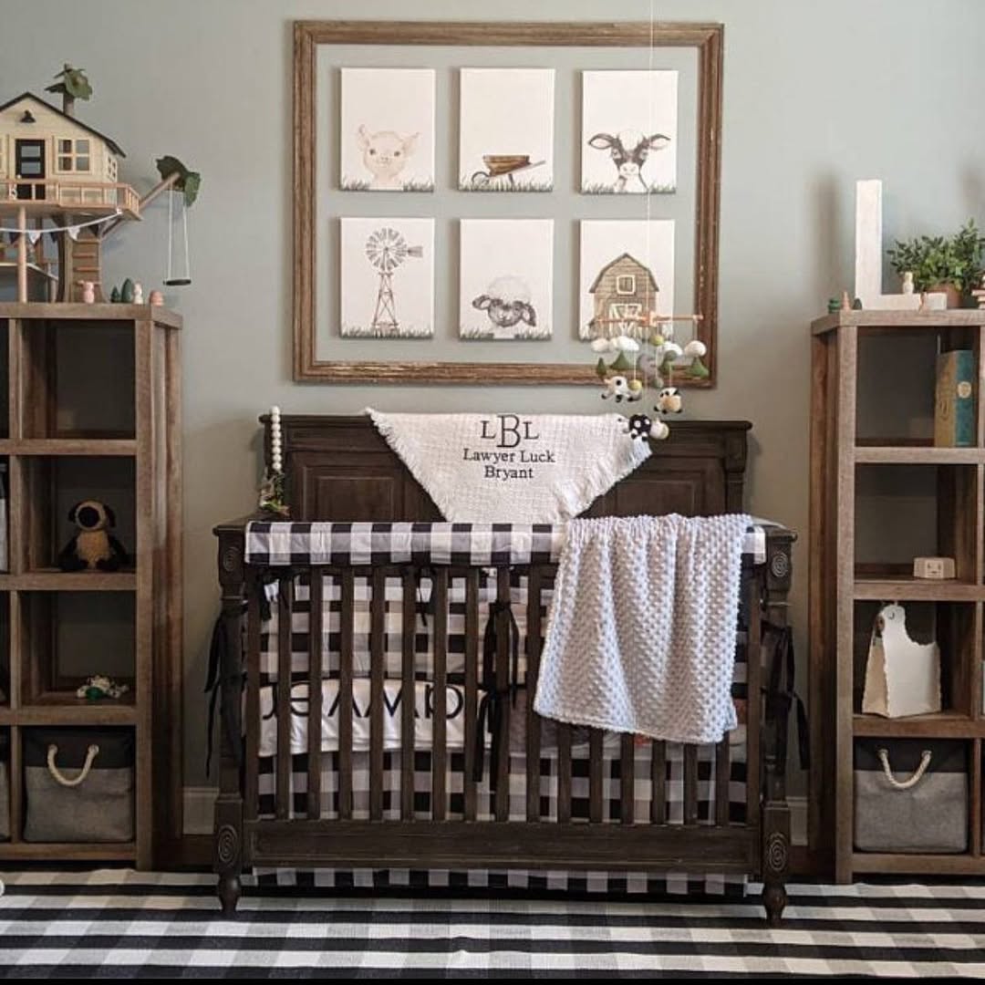 A wooden crib with a personalized blanket is centered between two shelves in a nursery. Animal-themed art hangs above, and toys and books decorate the shelves—perfect inspiration for baby boy nursery ideas in 2025.